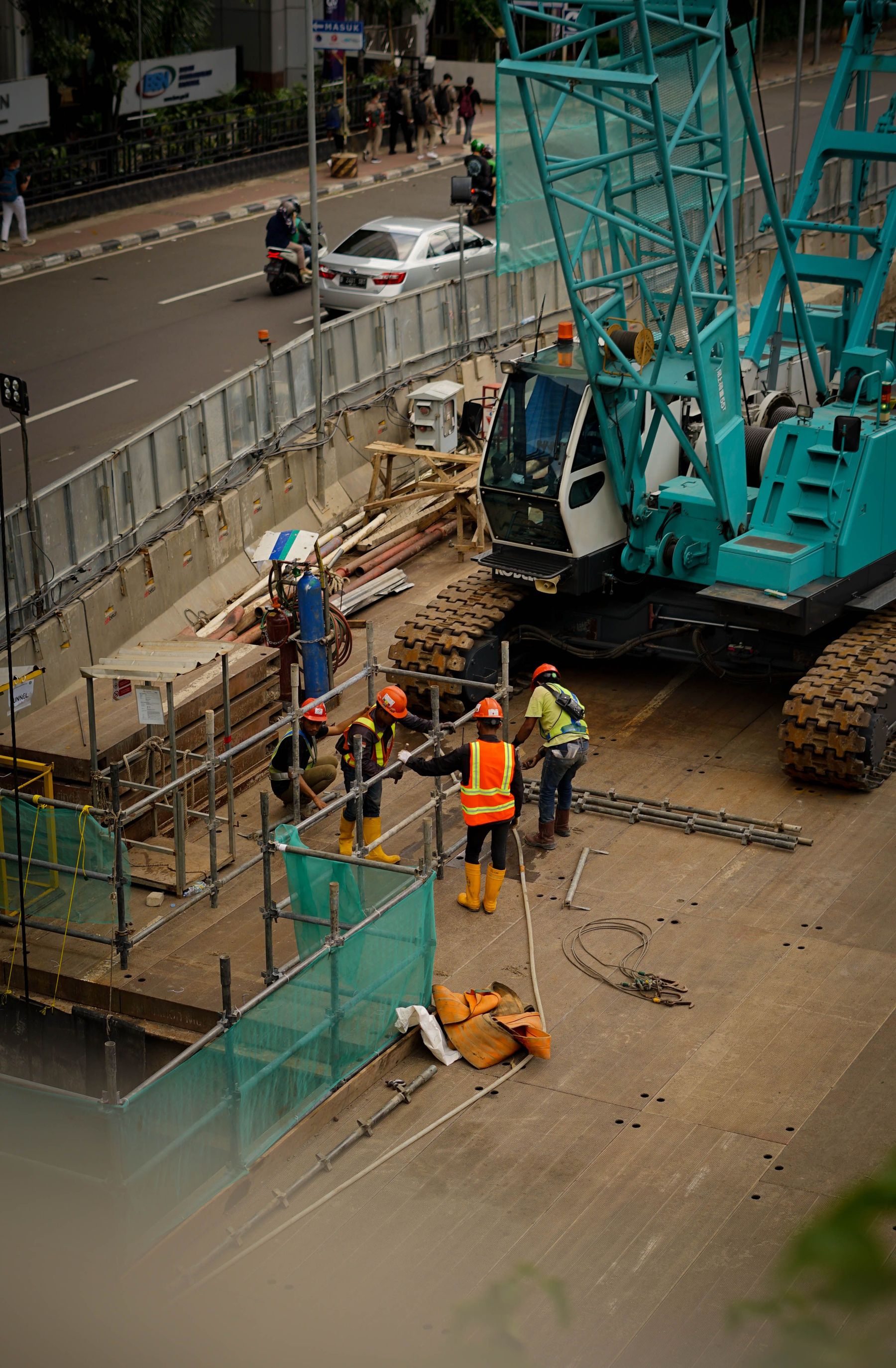 Illustrative elevated view of an urban tunnel construction site with a crawler crane and scaffolding, not an actual project