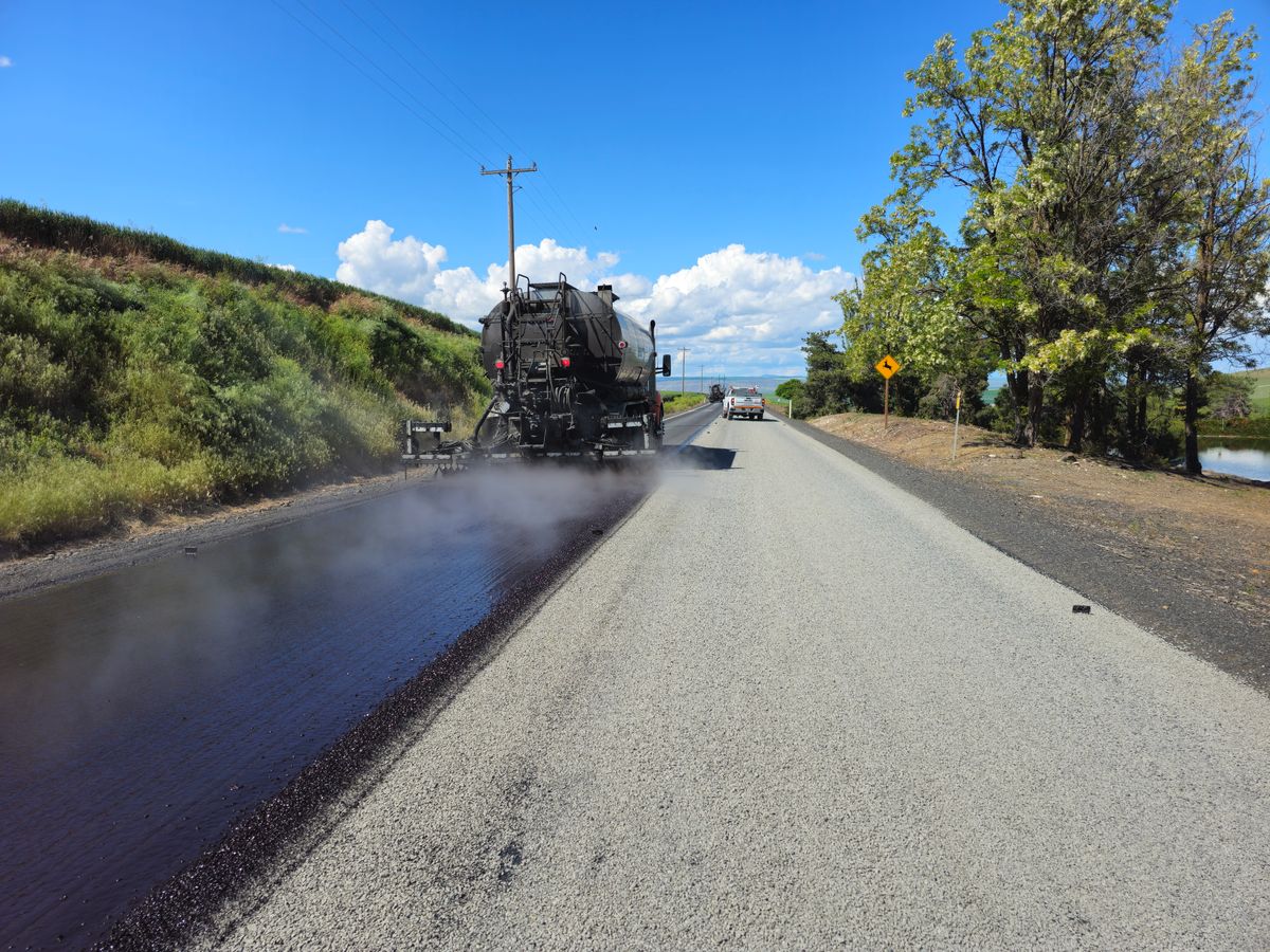 Illustrative asphalt paving machine resurfacing a highway, not an actual project